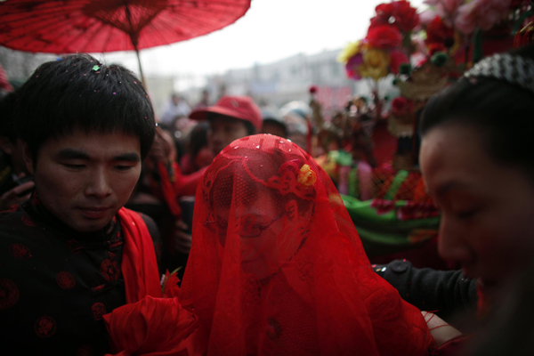 Rebecca Kanthor (C) and Liu Jian (L) arrive to their traditional Chinese wedding in Dong'an at the central province of Henan, February 9, 2011. [China Daily/Agencies]