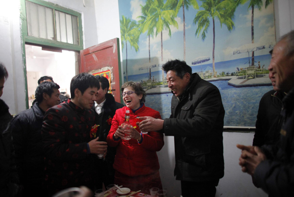 Liu Jian (L) and his wife Rebecca Kanthor celebrate with relatives after their traditional Chinese wedding in Dong'an at the central province of Henan, February 9, 2011. [China Daily/Agencies]