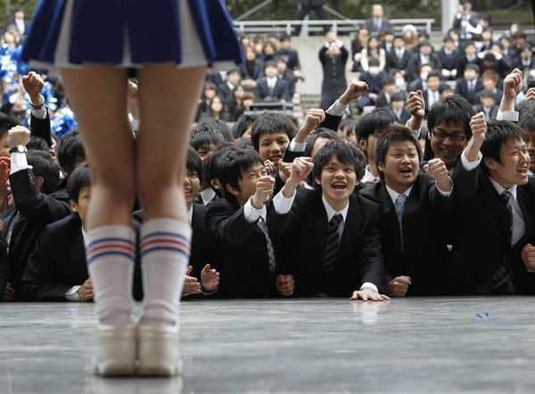  Japanese college students watch a cheerleader at a rally in Tokyo Feb 8, 2011. About 1,500 students from business schools attended the rally to boost their morale ahead of their job hunt. [China Daily/Agencies]