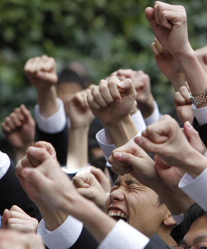 Japanese college students raise their fists at a rally in Tokyo Feb 8, 2011. [China Daily/Agencies]