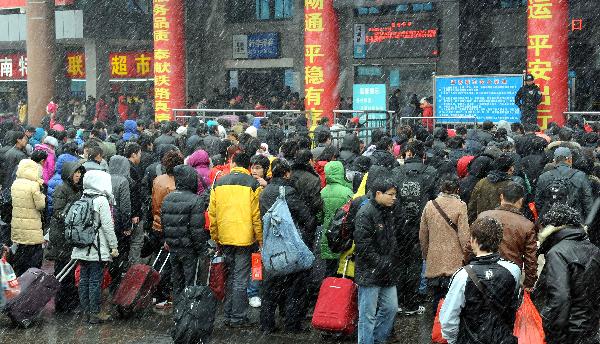 Crowds of passengers get into Zhengzhou Railway Station amid heavy snow during China&apos;s Spring Festival travel rush in Zhengzhou, capital of central China&apos;s Henan Province, Feb. 9, 2011. China&apos;s central area witnessed the first snow of this year on Wednesday. [Xinhua]