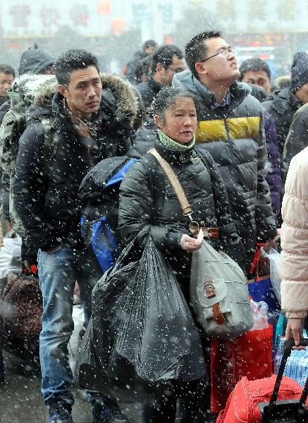 Passengers line up to get into Zhengzhou Railway Station amid heavy snow during China&apos;s Spring Festival travel rush in Zhengzhou, capital of central China&apos;s Henan Province, Feb. 9, 2011. China&apos;s central area witnessed the first snow of this year on Wednesday. [Xinhua]