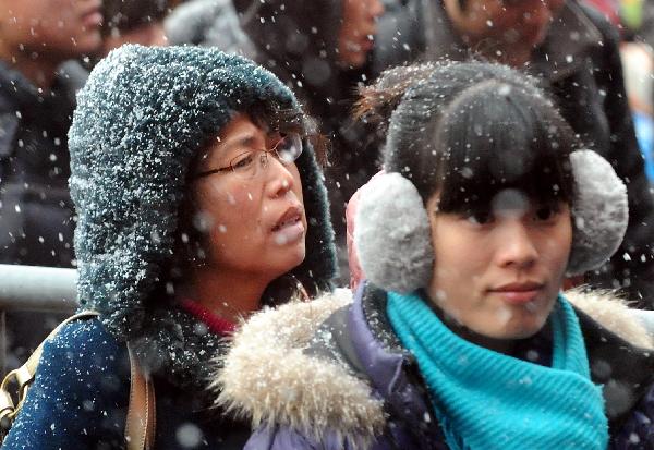 Passengers line up entering Zhengzhou Railway Station amid heavy snow during China&apos;s Spring Festival travel rush in Zhengzhou, capital of central China&apos;s Henan Province, Feb. 9, 2011. China&apos;s central area witnessed the first snow of this year on Wednesday. [Xinhua]