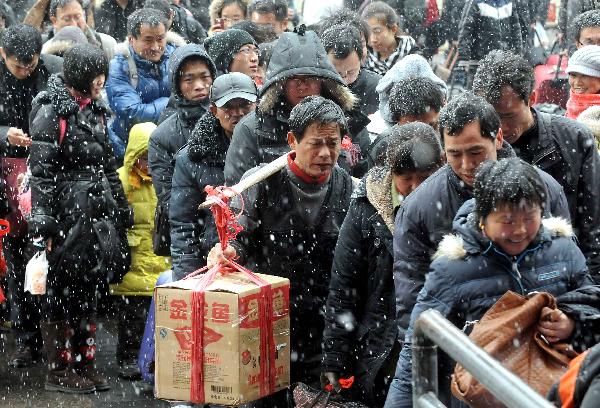 Crowds of passengers line up getting into Zhengzhou Railway Station amid heavy snow during China&apos;s Spring Festival travel rush in Zhengzhou, capital of central China&apos;s Henan Province, Feb. 9, 2011. China&apos;s central area witnessed the first snow of this year on Wednesday. [Xinhua]