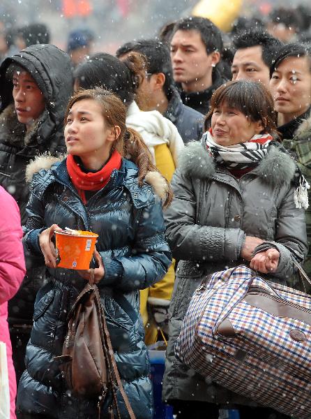 Passengers line up to get into Zhengzhou Railway Station amid heavy snow during China&apos;s Spring Festival travel rush in Zhengzhou, capital of central China&apos;s Henan Province, Feb. 9, 2011. China&apos;s central area witnessed the first snow of this year on Wednesday. [Xinhua] 