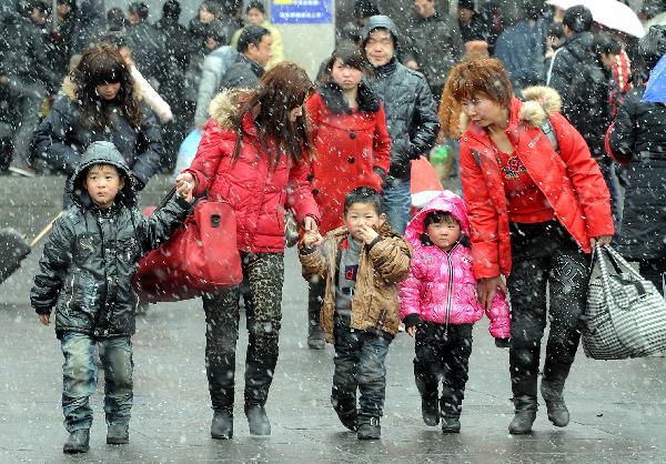 Several passengers walk amid heavy snow to get out of Zhengzhou Railway Station during China&apos;s Spring Festival travel rush in Zhengzhou, capital of central China&apos;s Henan Province, Feb. 9, 2011. China&apos;s central area witnessed the first snow of this year on Wednesday. [Xinhua]