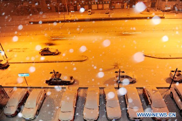 Snow-covered vehicles park aside the street in Beijing, capital of China, Feb. 10, 2011. It began to snow in Beijing on late Wednesday. It is the first snow this winter, which arrives as the latest snowfall in 60 years. [Xinhua] 