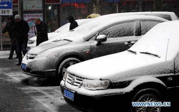 Citizens travel in snow in Zhengzhou, capital of central China&apos;s Henan Province, Feb. 9, 2011. Henan, one of the biggest farming provinces in China, saw long-awaited snowfalls Wednesday, which was expected to alleviate the prolonged drought that had ravaged the northern part of the country since last October.