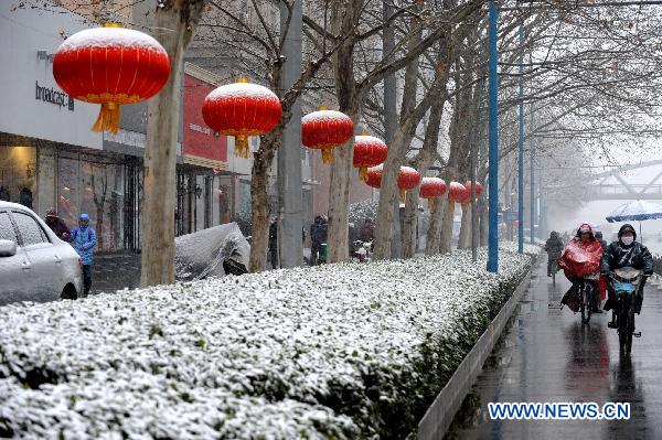 Citizens travel in snow in Zhengzhou, capital of central China&apos;s Henan Province, Feb. 9, 2011. Henan, one of the biggest farming provinces in China, saw long-awaited snowfalls Wednesday, which was expected to alleviate the prolonged drought that had ravaged the northern part of the country since last October.