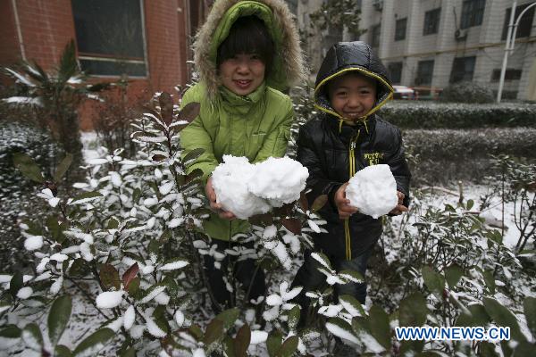 Citizens holds snowballs in Luoyang, central China&apos;s Henan Province, Feb. 9, 2011. Henan, one of the biggest farming provinces in China, saw long-awaited snowfalls Wednesday, which was expected to alleviate the prolonged drought that had ravaged the northern part of the country since last October. 
