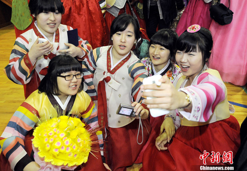 High school graduates wearing traditional Korean &apos;hanbok&apos; outfits bow deeply to their teachers and parents (R) during their graduation ceremony at Dongmyung Girls High School in Seoul Feb 10, 2011. [China Daily/Agencies]