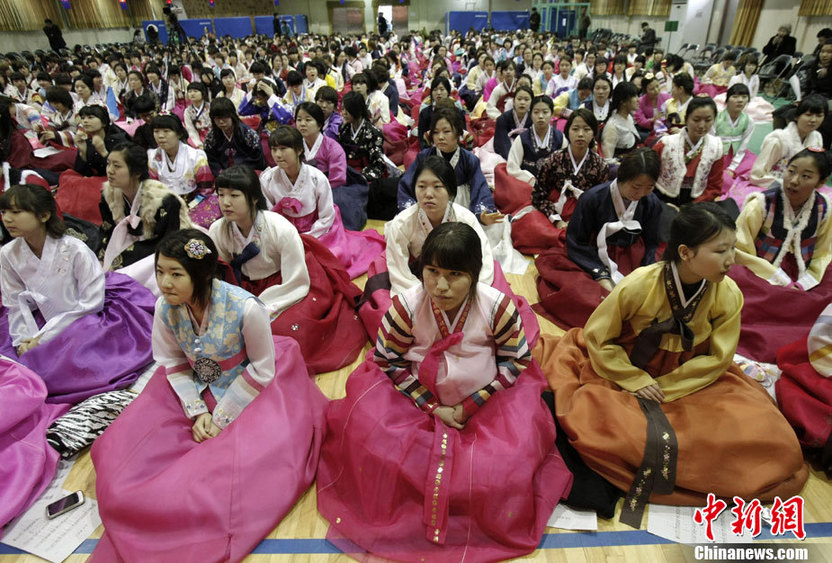 High school graduates wearing traditional Korean &apos;hanbok&apos; outfits bow deeply to their teachers and parents (R) during their graduation ceremony at Dongmyung Girls High School in Seoul Feb 10, 2011. [China Daily/Agencies]