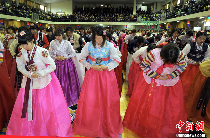 High school graduates wearing traditional Korean &apos;hanbok&apos; outfits bow deeply to their teachers and parents (R) during their graduation ceremony at Dongmyung Girls High School in Seoul Feb 10, 2011. [China Daily/Agencies]