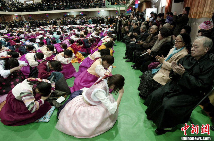 High school graduates wearing traditional Korean &apos;hanbok&apos; outfits bow deeply to their teachers and parents (R) during their graduation ceremony at Dongmyung Girls High School in Seoul Feb 10, 2011. [China Daily/Agencies]