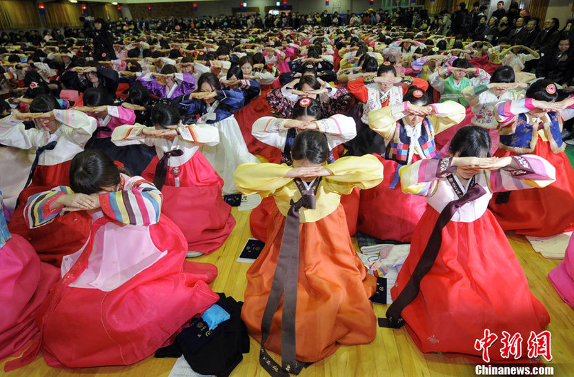 High school graduates wearing traditional Korean &apos;hanbok&apos; outfits bow deeply to their teachers and parents (R) during their graduation ceremony at Dongmyung Girls High School in Seoul Feb 10, 2011. [China Daily/Agencies]