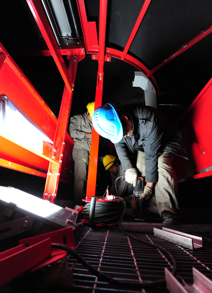 Photo taken on Feb. 10, 2011 shows workers fixing a baggage conveyor belt inside the new airport of Kunming, capital of south China&apos;s Yunnan Province. The investment of the new airport of Kunming has reached 14.26 billion RMB yuan, 75 percent of the project&apos;s total budget. [Xinhua] 