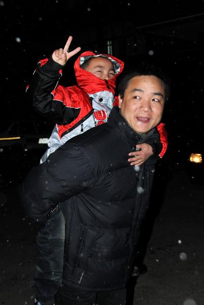 Peng Gaofeng carries his lost son Peng Wenle in the back in snow in Pizhou, east China&apos;s Jiangsu Province, Feb. 9, 2011. [Xinhua]