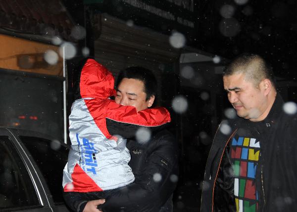 Peng Gaofeng (C) carries his lost son Peng Wenle in his arms in Pizhou, east China&apos;s Jiangsu Province, Feb. 9, 2011.[Xinhua]