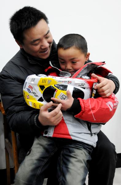 Peng Gaofeng holds his lost son Peng Wenle in his arms in Pizhou, east China&apos;s Jiangsu Province, Feb. 9, 2011.[Xinhua] 