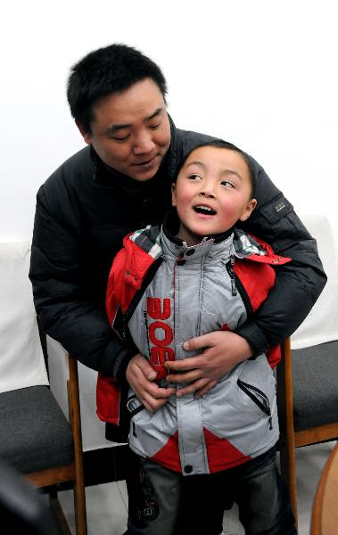 Peng Gaofeng holds his lost son Peng Wenle in his arms in Pizhou, east China&apos;s Jiangsu Province, Feb. 9, 2011.[Xinhua]