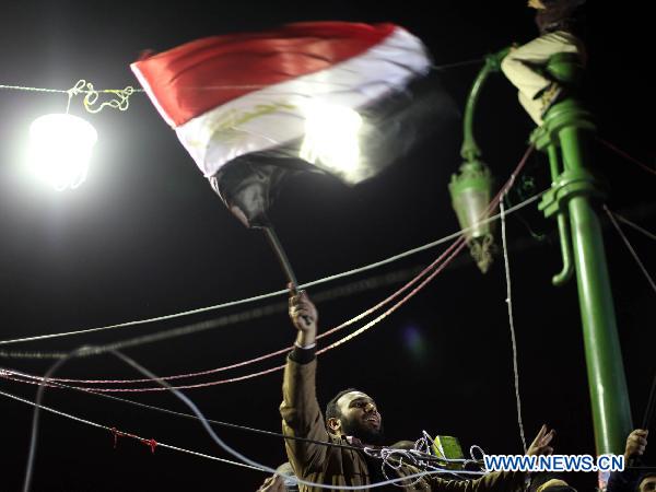 An Egyptian waves a flag during a protest demanding that Egyptian President Hosni Mubarak step down after listening to his speech at Tahrir Square in Cairo, capital of Egypt, Feb. 10, 2011. [Xinhua]