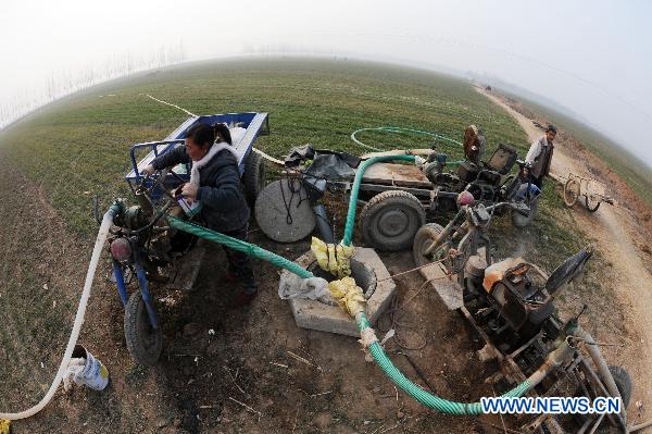 Farmers irrigate wheat field at Yangtulou Village of Bozhou City, east China's Anhui Province, Feb. 6, 2011. Farmers in Henan and Anhui provinces strived to fight against drought as the weather gets warm. [Xinhua]