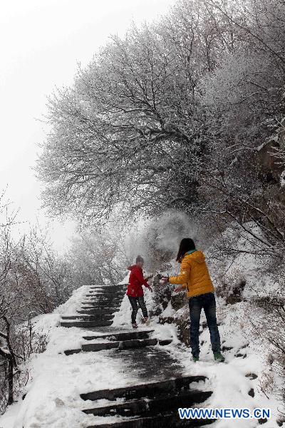 Tourists play with snow in Shennong Mountain scenic area in Qinyang, central China&apos;s Henan Province, Feb. 10, 2011. (Xinhua/Zhang Tianfeng) 