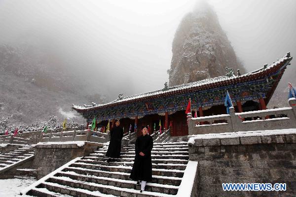 Taoist priests enjoy the view of snow in Shennong Mountain scenic area in Qinyang, central China&apos;s Henan Province, Feb. 10, 2011.