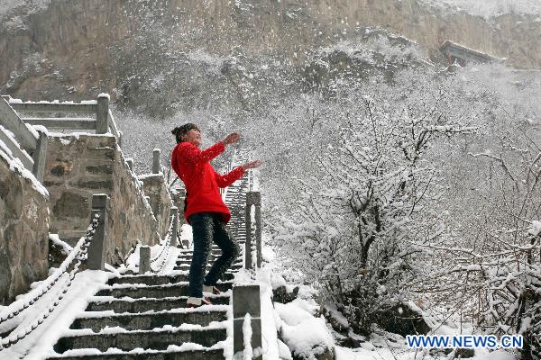 A tourist enjoys the view of snow in Shennong Mountain scenic area in Qinyang, central China&apos;s Henan Province, Feb. 10, 2011. 