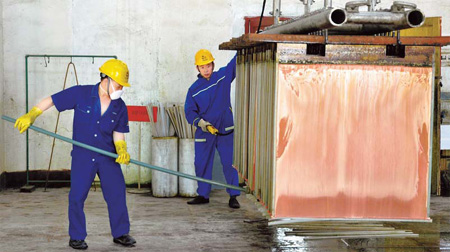Workers making copper products in Dexing city, Jiangxi province. China expects to produce about 12 million tons of recycled base metals in 2015, up from 6.33 million tons in 2009. [China Daily]