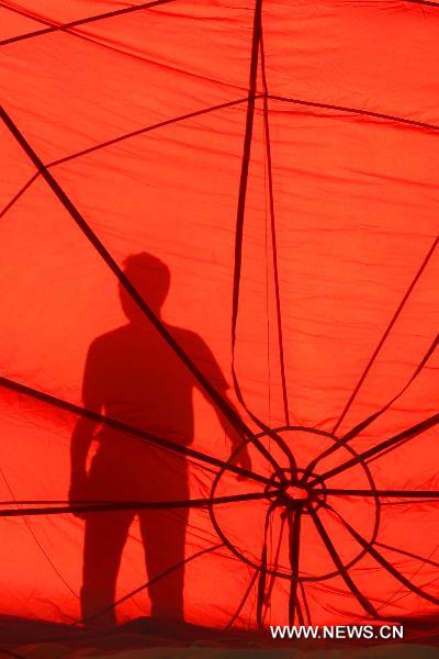 A hot-air balloon pilot casts a shadow in a balloon being inflated before its flight during the 16th Philippine International Hot-Air Balloon Fiesta at the Clark Freeport Zone in Pampanga, north of Manila, the Philippines, Feb. 10, 2011.