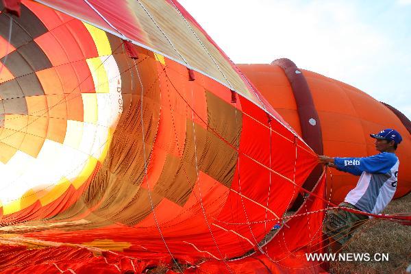 A man prepares to inflate a hot-air balloon before its flight during the 16th Philippine International Hot-Air Balloon Fiesta at the Clark Freeport Zone in Pampanga, north of Manila, the Philippines, Feb. 10, 2011.