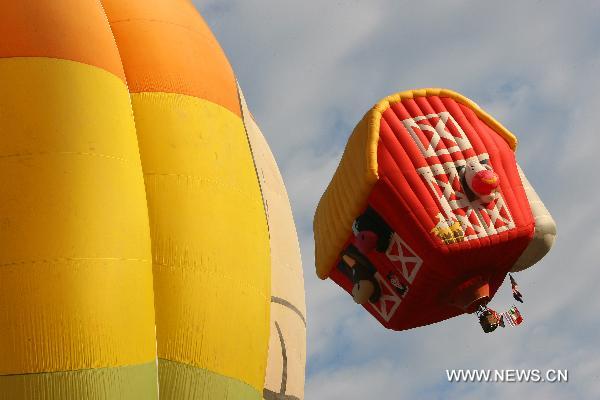 A barn-shaped hot-air balloon floats in the sky during the 16th Philippine International Hot-Air Balloon Fiesta at the Clark Freeport Zone in Pampanga, north of Manila, the Philippines, Feb. 10, 2011.