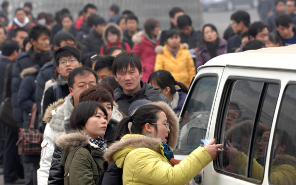 Students wait in line to enter a job fair where more than 200 companies are offering 1,000 posts, at a gym in Jinan, east China's Shandong Province, Feb 11, 2010. [Photo/Xinhua]