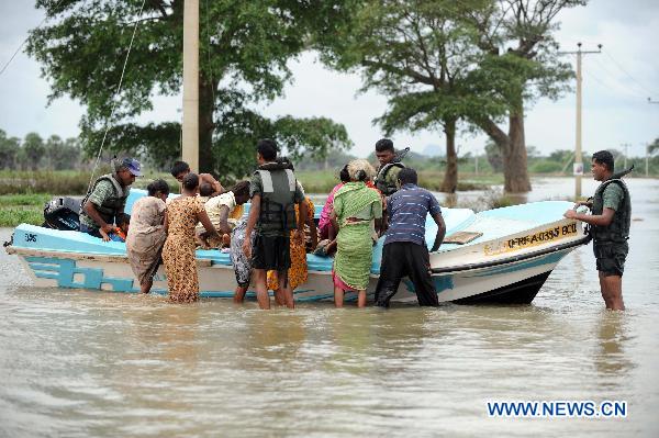 Sri Lankan soldiers help displaced people cross flooded road in the eastern district of Batticaloa, Sri Lanka, Feb. 10, 2011.