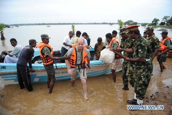 Sri Lankan soldiers help displaced people cross flooded road in the eastern district of Batticaloa, Sri Lanka, Feb. 10, 2011. 