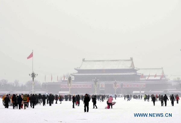 Tourists are seen in the Tian'anmen Square in Beijing, capital of China, Feb. 13, 2011. Beijing embraced the second snowfall this winter since Saturday night. 