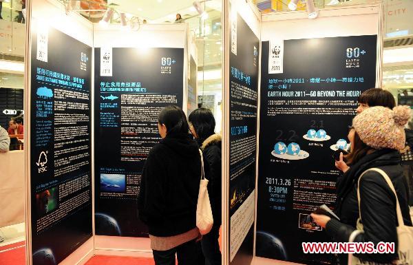 People read about WWF (World Wildlife Fund) Earth Hour at an exhibition in Hong Kong, south China, Feb. 13, 2011. Earth Hour, a global initiative powered by WWF to enhance people&apos;s support for environmentally sustainable action, will fall on 8:30 p.m. of March 26 this year.