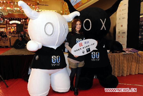 Hong Kong singer Kay Tse poses for photo with the cartoon character Andox and Box during the launching ceremony of WWF (World Wildlife Fund) Earth Hour in Hong Kong, south China, Feb. 13, 2011. Earth Hour, a global initiative powered by WWF to enhance people&apos;s support for environmentally sustainable action, will fall on 8:30 p.m. of March 26 this year. 