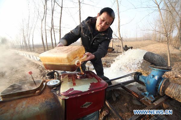 A technician refuels a water pump in Ganyu County, east China's Jiangsu Province, Feb. 14, 2011. Local government allocated 10 million yuan (1.52 million U.S. dollars) and dispatched more than 100 technicians to the farmlands for drought fight. 