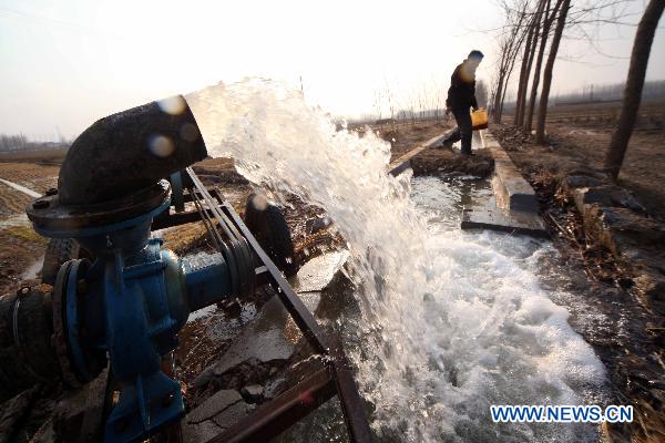 Water runs out of a pump in a wheat field in Ganyu County, east China's Jiangsu Province, Feb. 14, 2011. Local government allocated 10 million yuan (1.52 million U.S. dollars) and dispatched more than 100 technicians to the farmlands for drought fight. 