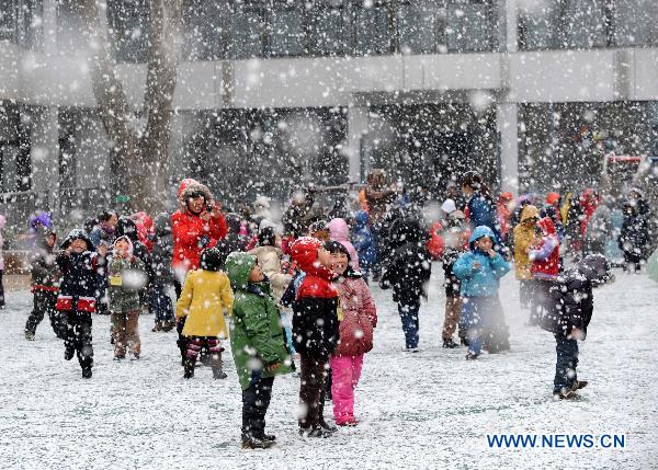 Pupils have fun on a school playground in Nanjing, capital of east China&apos;s Jiangsu Province, Feb. 14, 2011. Snowfalls exhilarated children as new semester began in elementary schools and kindergartens in Nanjing on Monday. [Xinhua] 