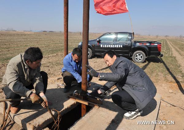 Technicians repair a motor-pumped well at Jishan County, north China&apos;s Shanxi Province, Feb. 14, 2011. The local government has dispatched eight technical support teams equipped with water pumps and tankers to help farms with their anti-drought fight during the spring farming season. 