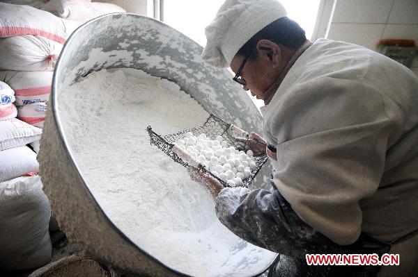 Chef Hu makes Yuanxiao (glutinous rice flour dumpling with sweetened stuffing) at a food shop in Taiyuan, capital of north China's Shanxi Province, Feb. 15, 2011. Yuanxiao is eaten in China's Lantern Festival, a traditional festival for family reunion. [Fan Minda/Xinhua] 