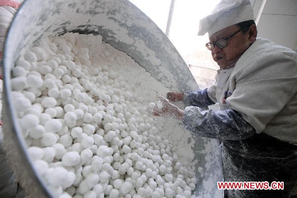 Chef Hu makes Yuanxiao (glutinous rice flour dumpling with sweetened stuffing) at a food shop in Taiyuan, capital of north China's Shanxi Province, Feb. 15, 2011. Yuanxiao is eaten in China's Lantern Festival, a traditional festival for family reunion. [Fan Minda/Xinhua]