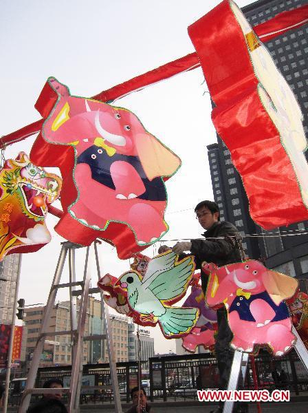 A staff member hangs lanterns in downtown Taiyuan, capital of north China's Shanxi Province, Feb. 15, 2011. This year's Lantern Festival, which is the 15th day of the first month of Chinese Lunar New Year, falls on Feb. 17. [Yan Yan/Xinhua]