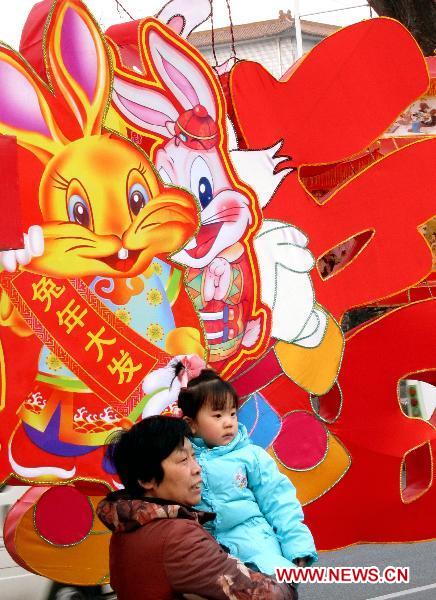 Citizens pose with a large lantern with rabbits image in downtown Taiyuan, capital of north China's Shanxi Province, Feb. 15, 2011. This year's Lantern Festival, which is the 15th day of the first month of Chinese Lunar New Year, falls on Feb. 17. [Yan Yan/Xinhua]