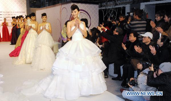 Chinese mainland models present wedding dresses during a fashion show at the ongoing International Flower Expo in Taipei, southeast China's Taiwan, Feb. 15, 2011.