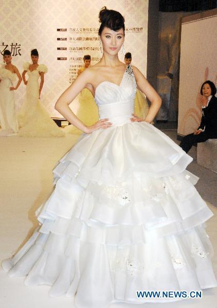 A Chinese mainland model presents a wedding dress during a fashion show at the ongoing International Flower Expo in Taipei, southeast China's Taiwan, Feb. 15, 2011.