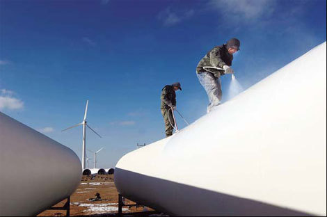 Workers paint wind turbines in Yumen, Gansu province. Due to poor transmission capabilities and grid connection in Northwest China, new wind projects are being built in other provinces. [China Daily via agencies]